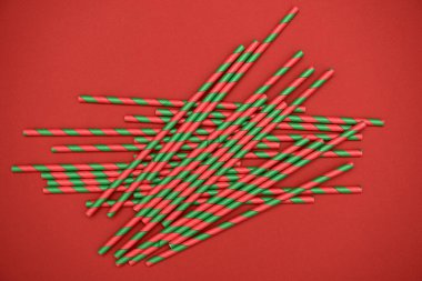 Kırmızı arkaplanda kırmızı ve yeşil çizgili pipetler, boşluğu kopyala