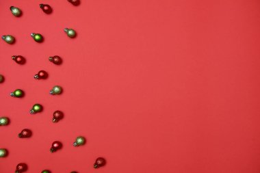 Kırmızı arka planda kırmızı ve yeşil takılar olan yaratıcı Noel deseni