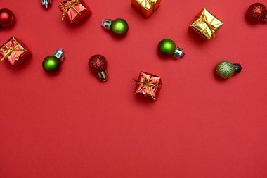 Kırmızı ve yeşil parlak mücevherleri ve kırmızı arka planda hediyeleri olan yaratıcı Noel deseni