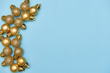 Mavi pastel arka planda altın parlak mücevherlerle yaratıcı Noel deseni