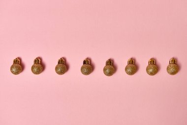 Pastel pembe arka planda altın gibi parlak mücevherleri olan yaratıcı Noel deseni