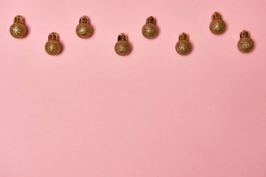 Pastel pembe arka planda altın gibi parlak mücevherleri olan yaratıcı Noel deseni