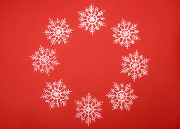 กรอบวงกลมของเกล็ดหิมะสีขาวบนพื้นหลังสีแดง, พื้นที่สําเนา เนื้อเยื่อคริสต์มาส — ภาพถ่ายสต็อก