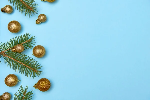 Kreatív karácsonyi minta arany fényes baubles és fenyő ágak pasztell kék háttér — Stock Fotó