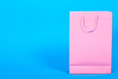 Pembe alışveriş çantası mavi arkaplanda izole edildi, boşluğu kopyala