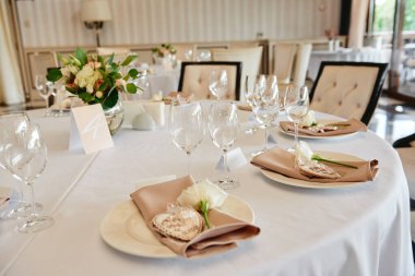 Masada köpüklü şarap kadehleri ve çatal bıçak takımı var.