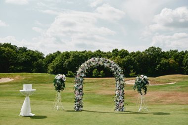 Beyaz ve pembe güllerle süslenmiş güzel bir düğün kemeri.