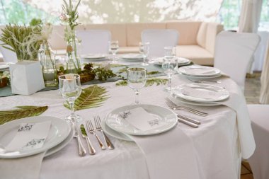 Masada köpüklü şarap kadehleri ve çatal bıçak takımı var.