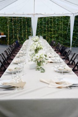 Dışarıdaki düğün resepsiyonunda köpüklü şarap kadehleri ve çatal bıçak seti.