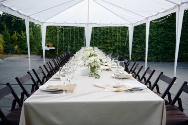 Dışarıdaki düğün resepsiyonunda köpüklü şarap kadehleri ve çatal bıçak seti.