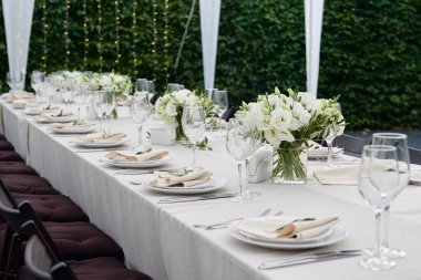 Dışarıdaki düğün resepsiyonunda köpüklü şarap kadehleri ve çatal bıçak seti.