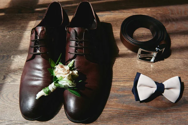 Kahverengi erkek ayakkabılarını, papyonunu, kemerini ve yaka çiçeğini kapat. — Stok fotoğraf