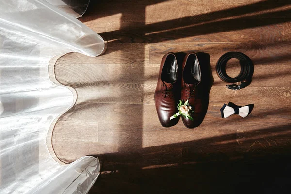 Close up of brown male shoes, bowtie, belt and  boutonniere on w — Stock Photo, Image