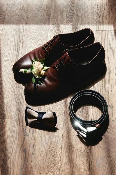Kahverengi erkek ayakkabılarını, papyonunu, kemerini ve yaka çiçeğini kapat. — Stok fotoğraf