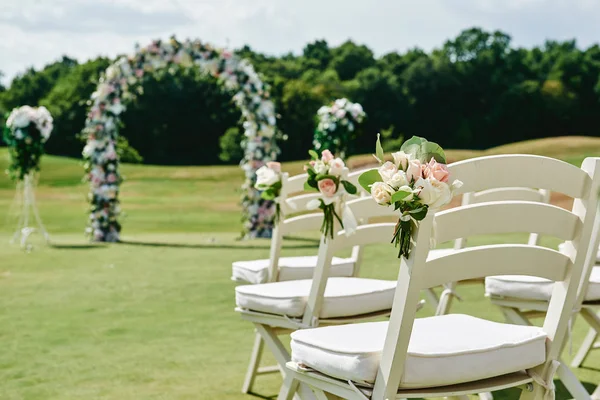 White wooden chairs with rose flowers on each side of archway ou — Stock Photo, Image