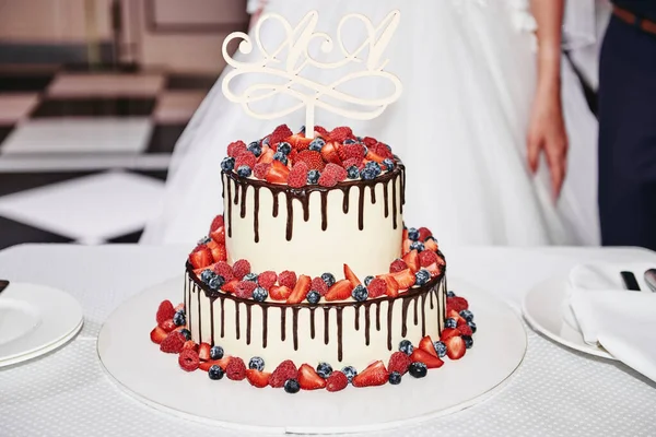 Elegant vit bröllopstårta dekorerad med färska bär och choc — Stockfoto