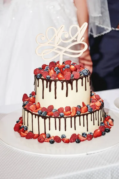 新鮮なベリーとチョックで装飾されたエレガントな白いウェディングケーキ — ストック写真