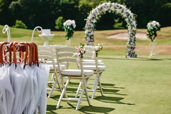 White wooden chairs with rose flowers on each side of archway ou — Stock Photo, Image