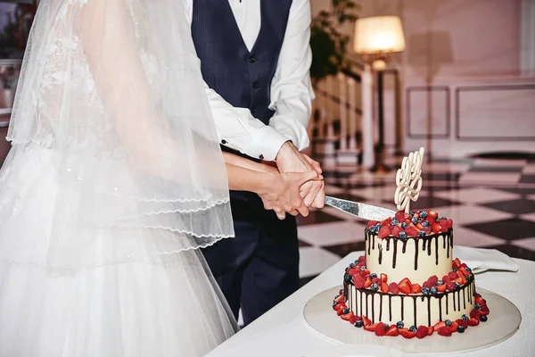 Невеста и жених вырезать элегантный белый свадебный торт украшен с — стоковое фото
