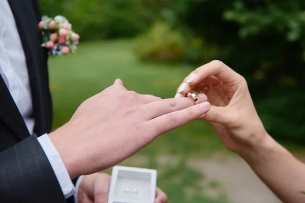 Noiva que põe anel de casamento no dedo do noivo no cerem de casamento — Fotografia de Stock