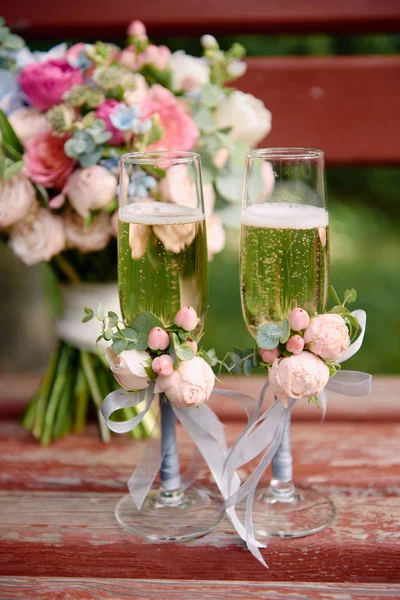 Copos de casamento espumantes com champanhe e buquê de casamento em — Fotografia de Stock