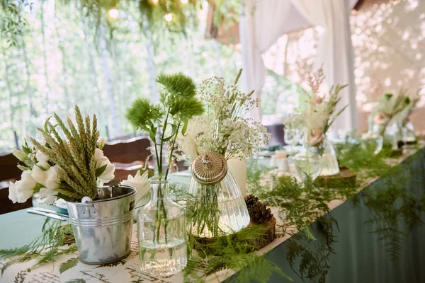 Belo arranjo floral em vaso de vidro na mesa de casamento em r — Fotografia de Stock