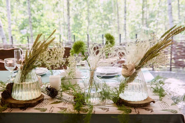 Krásné květinové aranžmá ve skleněné váze na svatební stůl v r — Stock fotografie