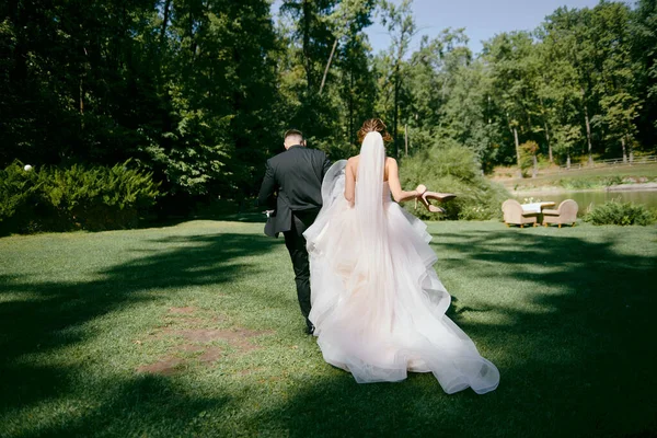 Retrato de corpo de comprimento total de noiva jovem e noivo andando no parque — Fotografia de Stock