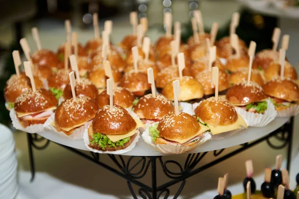 Buffet table with mini hamburgers at luxury wedding reception, c