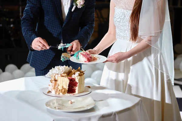 Happy bride and groom cut wedding cake decorated with flowers an — 스톡 사진