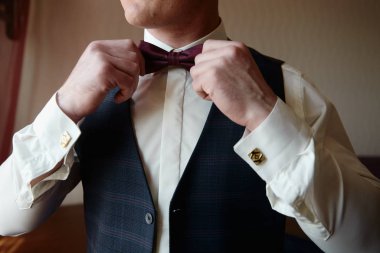 Beyaz gömlekli bir adam kırmızı papyon takıyor. İş adamı kılığına girmiş.