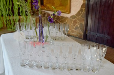 Restorandaki yemek masasında köpüklü cam eşyalar ve çiçekler, fotokopi odası. Kristal bardaklar kutlama için hazır