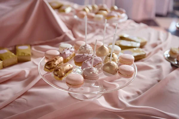 Snoep bar geserveerd met macarons, choux gebak en cake pops in restaurant, kopieer ruimte. Dessert tafel voor party roze kleur — Stockfoto