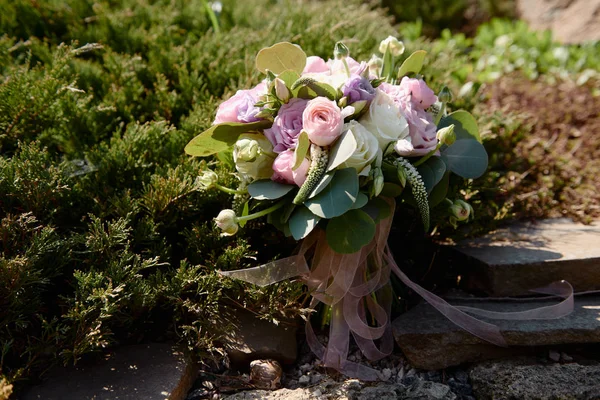 Primer plano del ramo nupcial de flores rosadas y púrpuras sobre fondo de piedra al aire libre — Foto de Stock