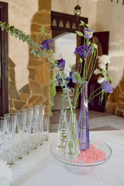 在餐厅的婚宴桌上布置漂亮的花卉,复制空间. 玻璃瓶中的紫色桉树和绿叶芬芳 — 图库照片