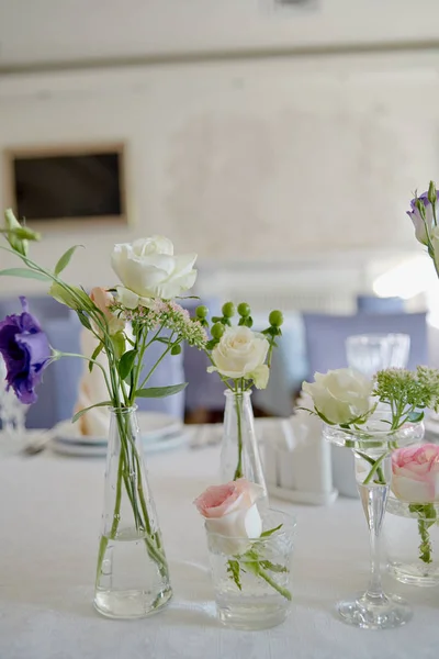 在餐厅的婚宴桌上布置漂亮的花卉,复制空间. 玻璃瓶中的粉红色玫瑰、紫色桉树和绿叶的芬芳. — 图库照片