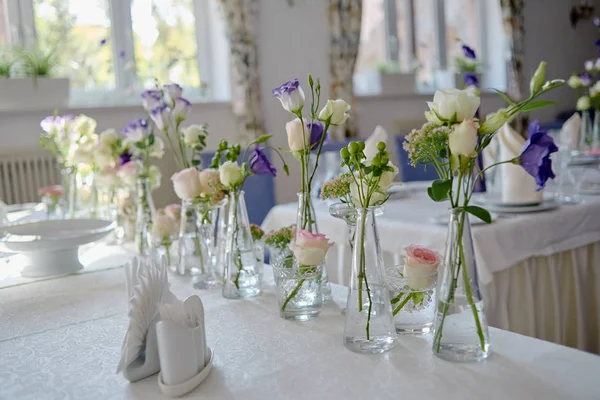 在餐厅的婚宴桌上布置漂亮的花卉,复制空间. 玻璃瓶中的粉红色玫瑰、紫色桉树和绿叶的芬芳. — 图库照片