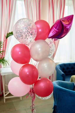 Wedding or birthday photo zone with pink, red and white balloons indoors, copy space. Holiday party decoration