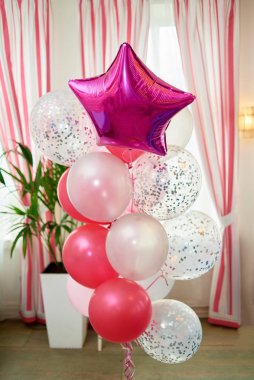 Wedding or birthday photo zone with pink, red and white balloons indoors, copy space. Holiday party decoration