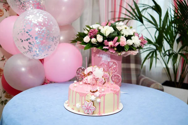 Round pink birthday cake decorated with lollipops, gingerbreads, flowers, beads number two on the top — Stock Photo, Image