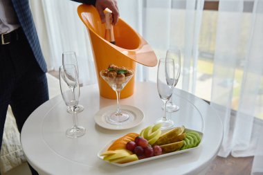 Takım elbiseli bir adam şampanya şişesini camdan içeri dolduruyor, kopyalama alanı. Şampanya partisi. Düğün resepsiyonu