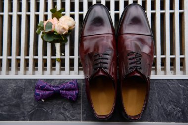 Kahverengi erkek ayakkabıları, papyon ve yaka çiçekleri, fotokopi alanı. Modern erkek aksesuarları. Düğün detayları