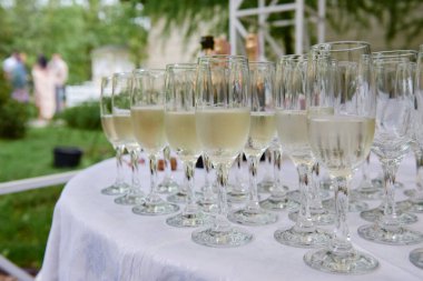 Restorandaki yemek masasında şarap ve şampanya ile köpüklü cam eşyalar, fotokopi odası. Kristal bardaklar kutlamaya hazır. Lüks düğün resepsiyonunda şarap kadehleri
