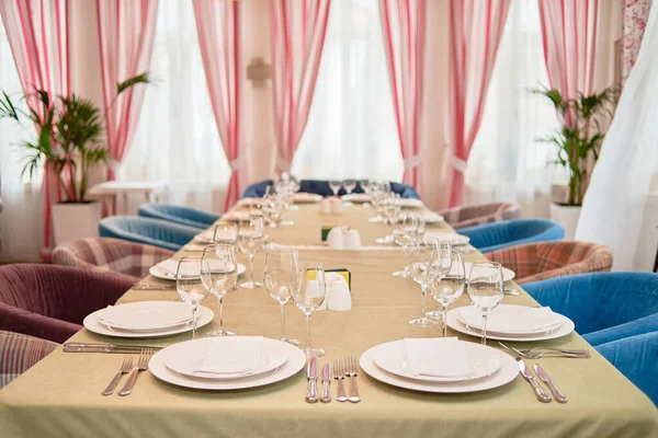 Набор стола с белыми тарелками, салфетками, столовыми приборами и бокалами — стоковое фото