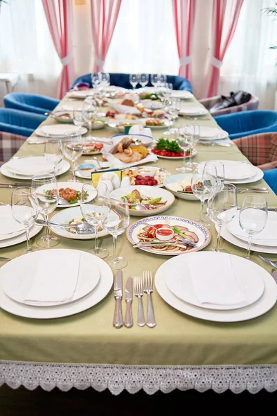 Набір столів з білими тарілками, серветками, столовими приборами та келихами — стокове фото