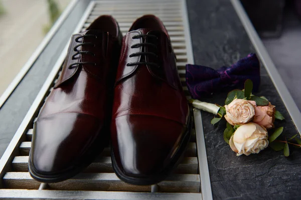 Kahverengi erkek ayakkabıları, papyon ve yaka çiçekleri, fotokopi alanı. Modern erkek aksesuarları. Düğün detayları — Stok fotoğraf