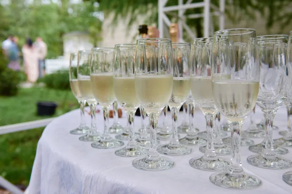 Sparkling glassware with wine and champagne on dinner table in restaurant, copy space. Crystal glasses ready for celebration. Wineglasses at luxury wedding reception outdoors