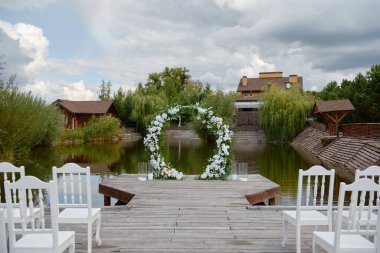 Düğün için açık alan, fotokopi alanı. Kemer yolunun her iki tarafında çiçekler ve sandalyelerle süslenmiş düğün kemeri. Düğün ayarları