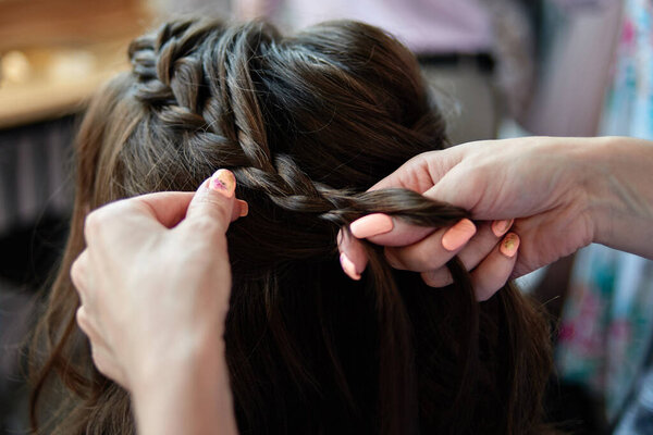 Hairdresser making hairstyle for woman, copy space. Bride morning. Wedding hairstyle on long hair, close up