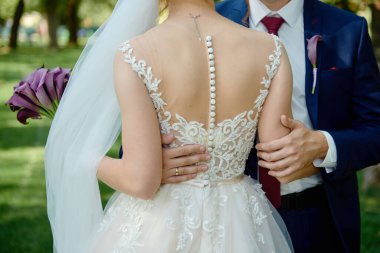 Mutlu düğün çifti bahçede yürüyor, fotokopi odası. Genç gelin ve damadın açık havada kucaklaşması.